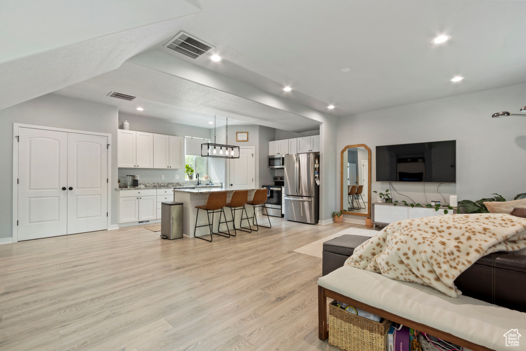 Living area with light wood-style floors and recessed lighting