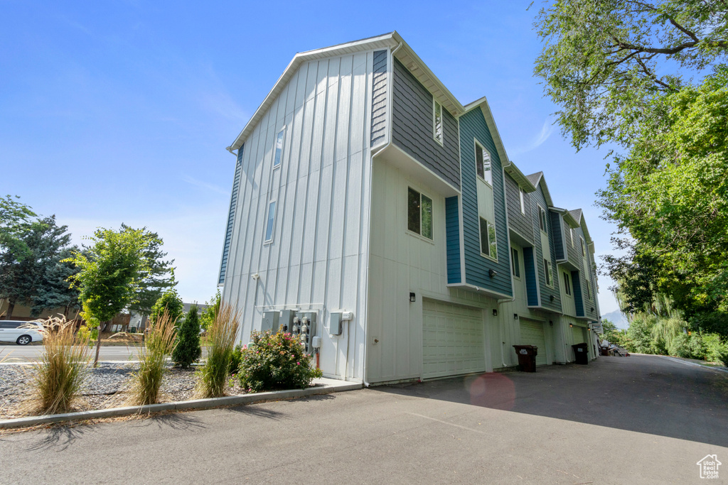 View of home's exterior featuring board and batten siding, an attached garage, and driveway