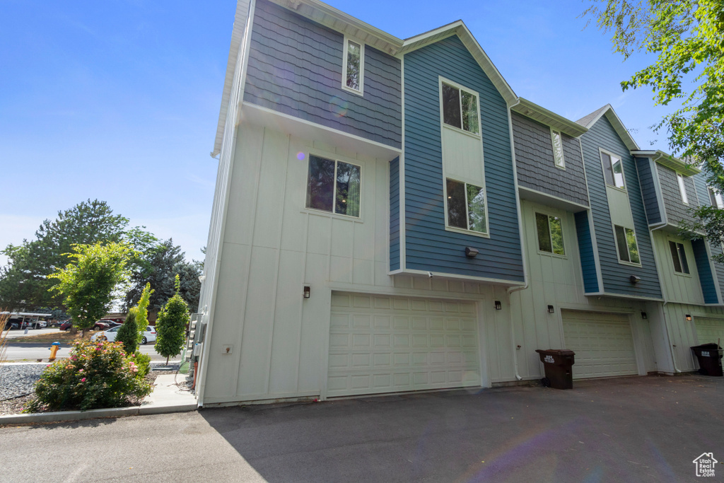 Back of house with board and batten siding and a garage