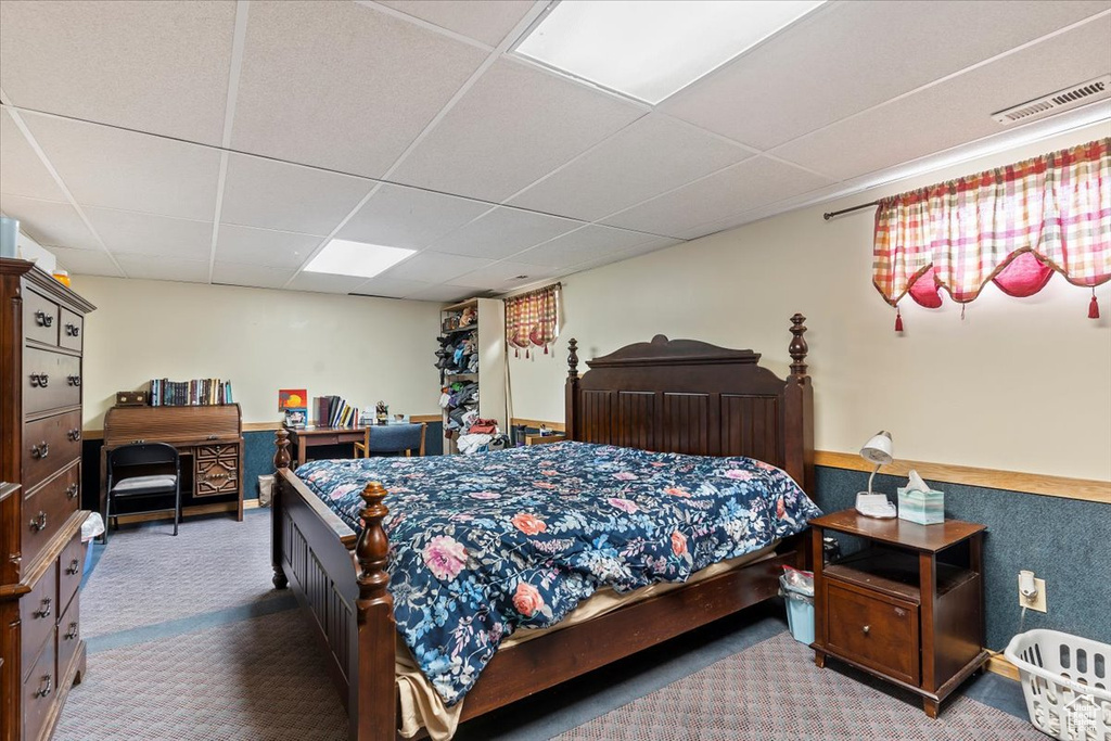 Bedroom with carpet flooring and a drop ceiling