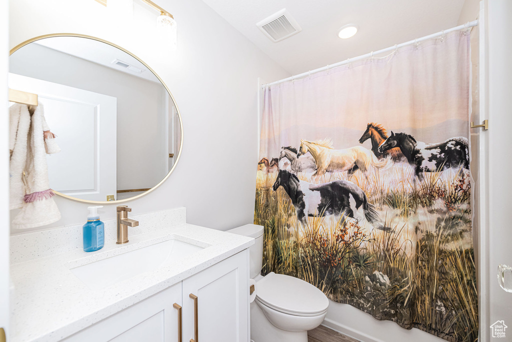 Full bathroom with vanity, a shower with shower curtain, recessed lighting, and wood finished floors