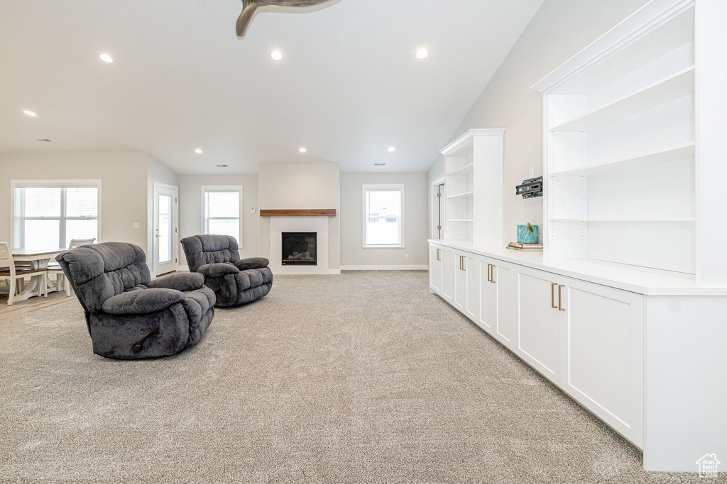 Living room with recessed lighting, a fireplace, light carpet, and ceiling fan