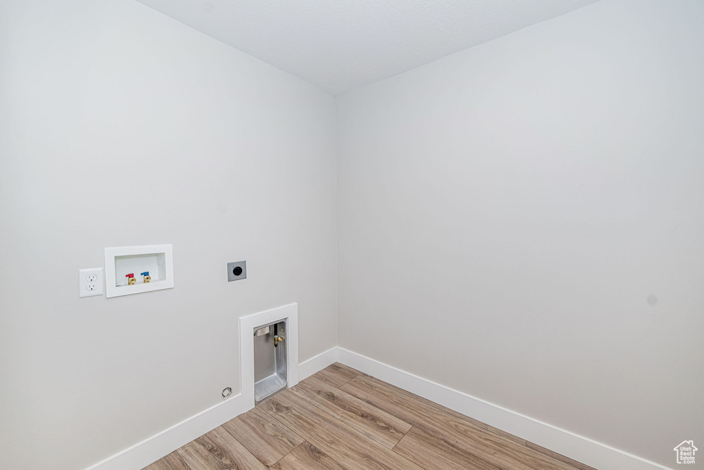 Laundry room featuring electric dryer hookup, hookup for a washing machine, light wood finished floors, and gas dryer hookup