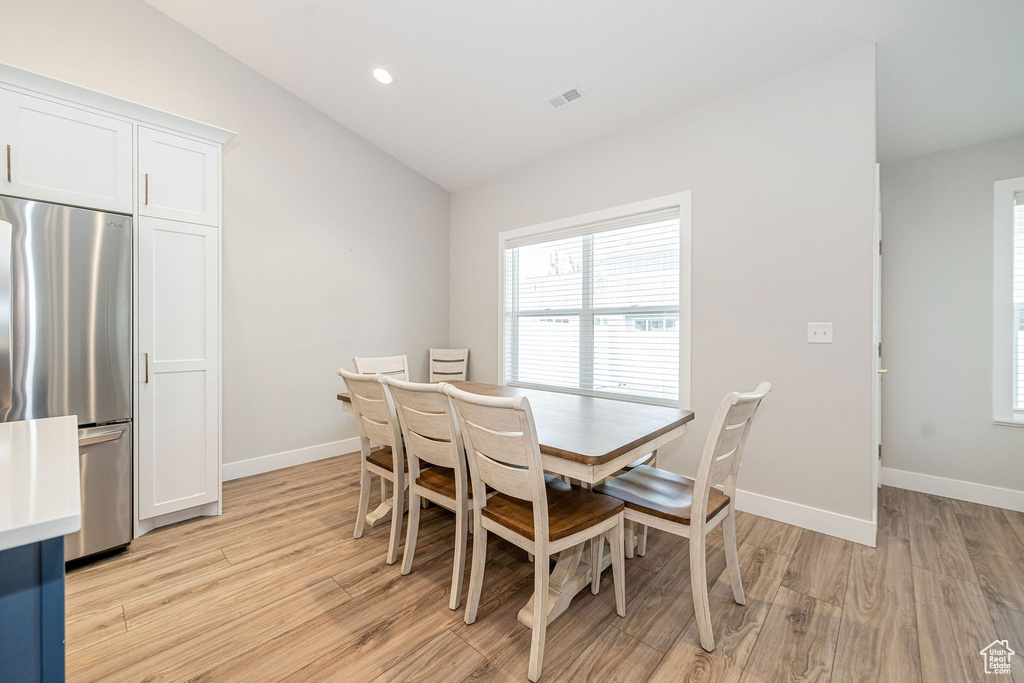 Dining room featuring lofted ceiling, light wood-type flooring, and recessed lighting