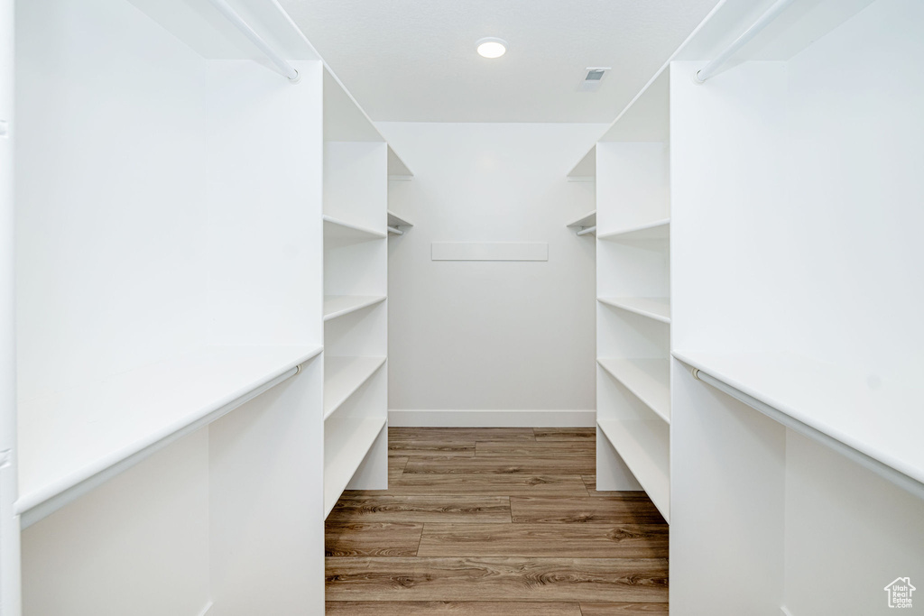 Walk in closet with light wood-style floors
