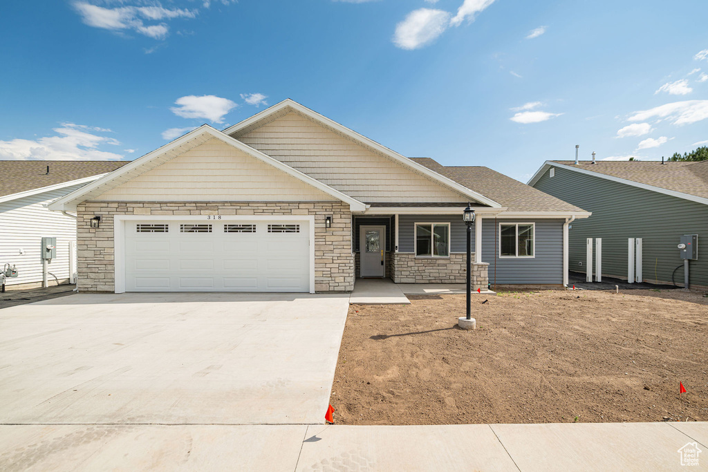 View of front facade featuring concrete driveway, a garage, stone siding, a porch, and a shingled roof