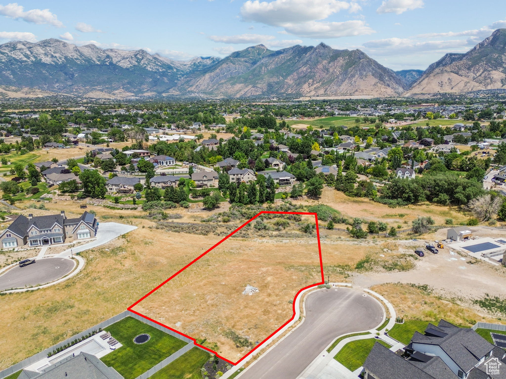 Aerial view of residential area featuring property parcel outlined and mountains