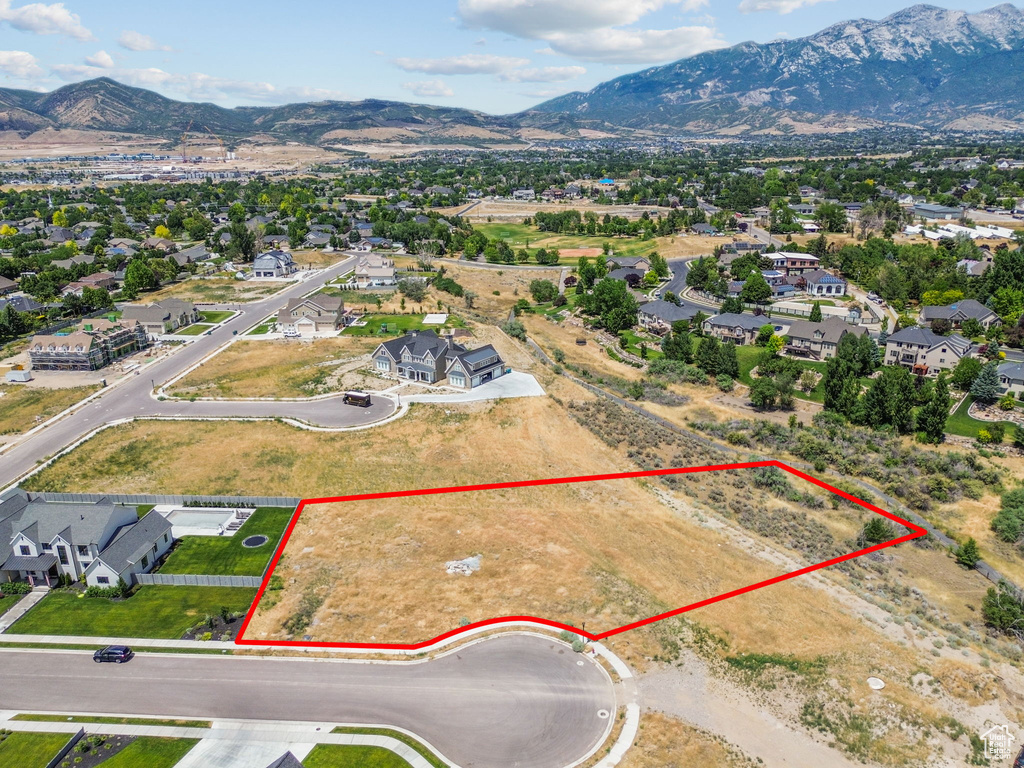 Aerial perspective of suburban area with mountains and property parcel outlined