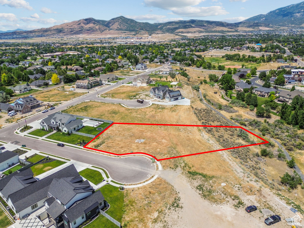 Aerial perspective of suburban area featuring a mountainous background and property boundaries highlighted