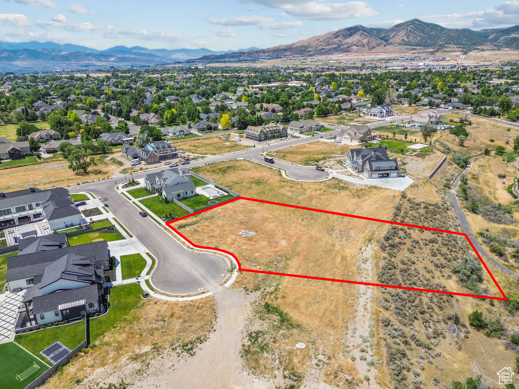 Aerial perspective of suburban area featuring mountains and property parcel outlined