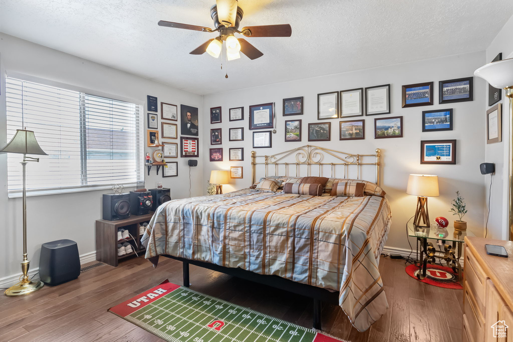 Bedroom featuring wood finished floors, ceiling fan, and a textured ceiling