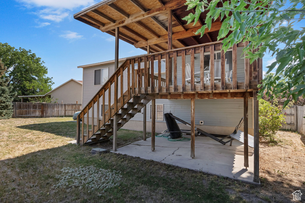Fenced backyard featuring a patio, stairs, and a deck