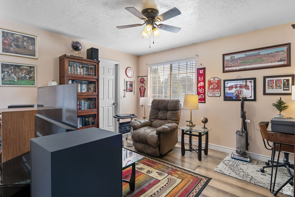 Office area featuring a textured ceiling, ceiling fan, and wood finished floors