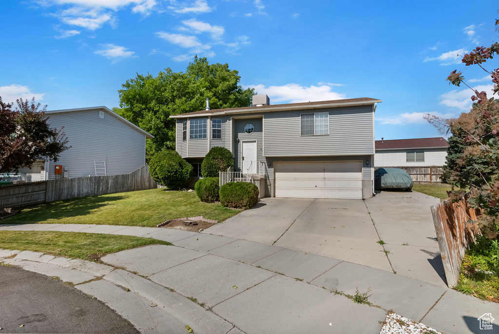 View of front facade with concrete driveway and an attached garage