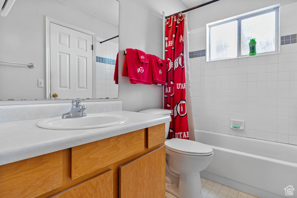Bathroom with vanity, shower / tub combo, and tile patterned floors