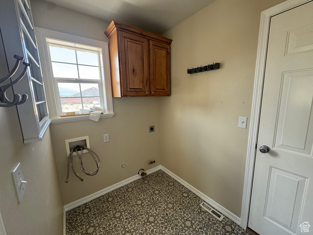 Laundry room featuring electric dryer hookup, hookup for a washing machine, hookup for a gas dryer, cabinet space, and tile patterned floors