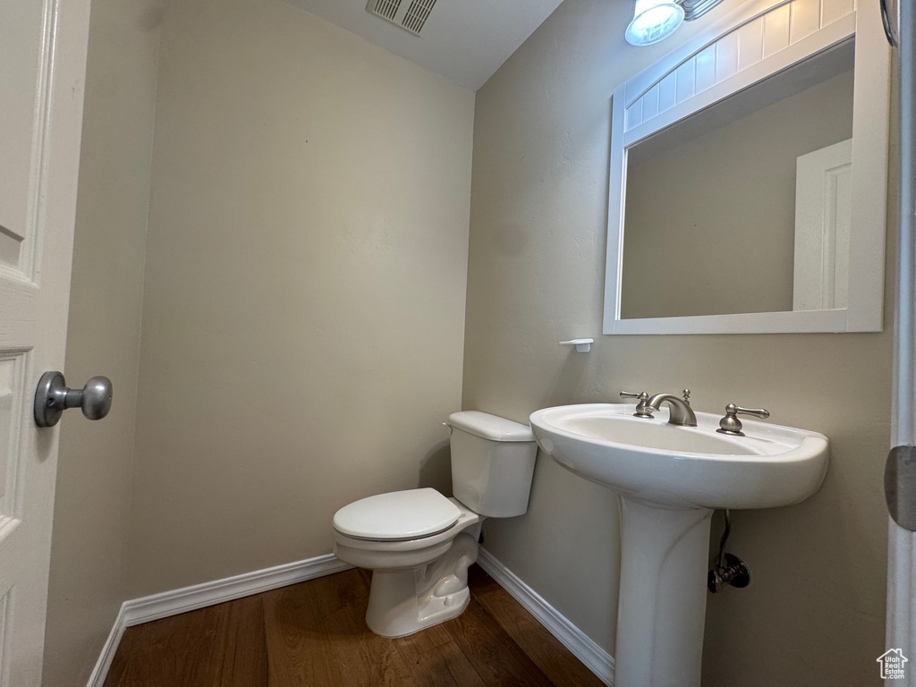 Bathroom featuring wood finished floors and toilet