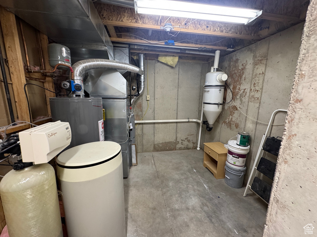 Unfinished below grade area featuring a water softener system and a central vacuum unit