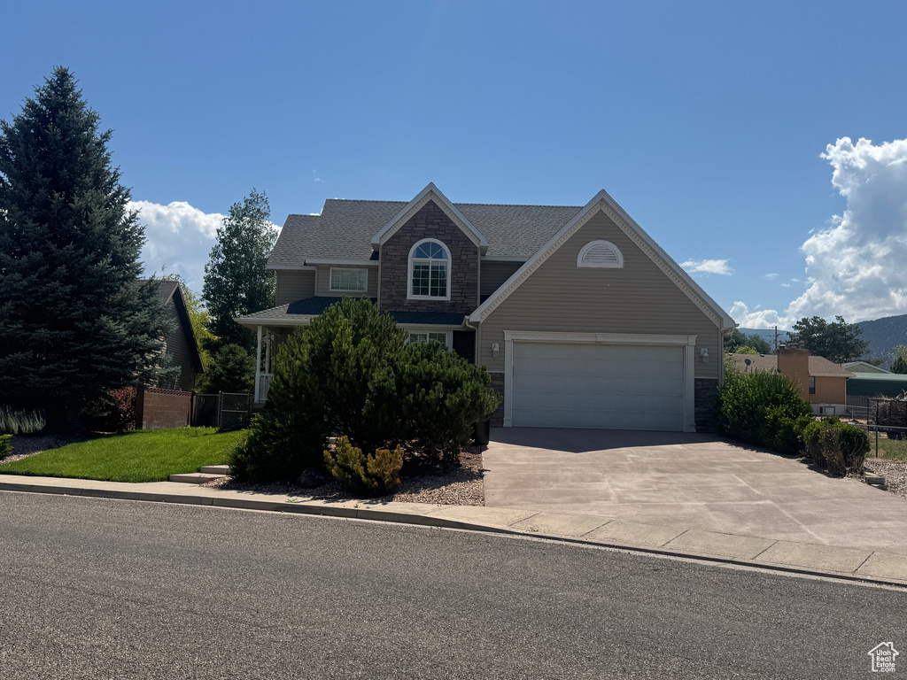 Traditional home with concrete driveway, stone siding, and a garage