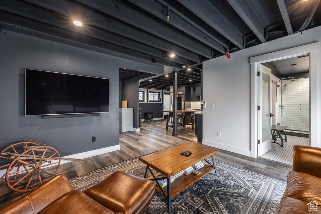 Living area with wood finished floors and beam ceiling