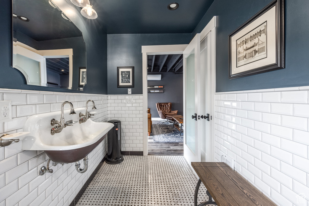 Bathroom with tile walls, wainscoting, and tile patterned floors