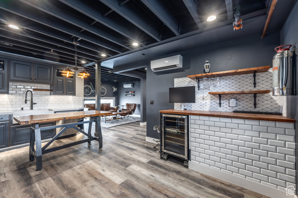 Kitchen with wood counters, beverage cooler, a wall mounted AC, tasteful backsplash, and light wood-style floors