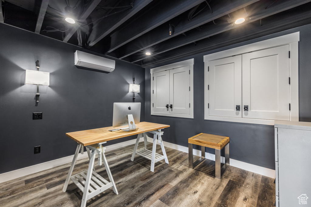 Office area featuring a wall unit AC and dark wood-style floors