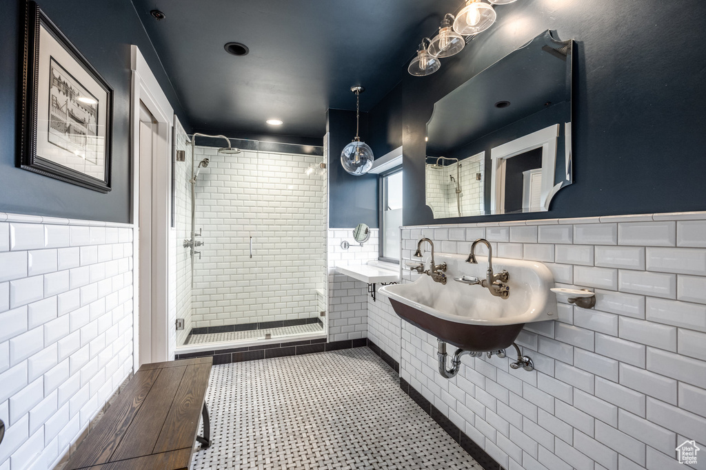 Bathroom featuring tile walls, a shower stall, and wainscoting
