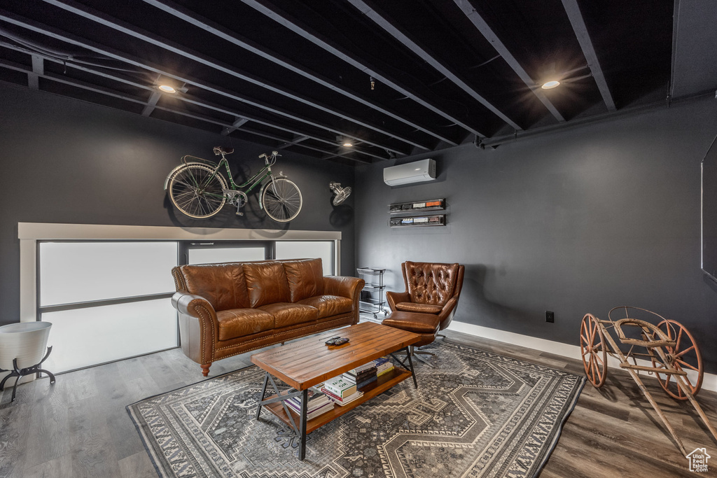 Living room with a wall mounted AC, wood finished floors, beam ceiling, and a chandelier