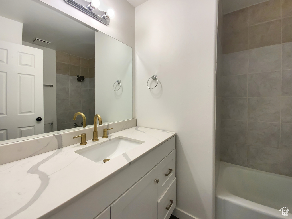 Bathroom with vanity and shower / tub combination