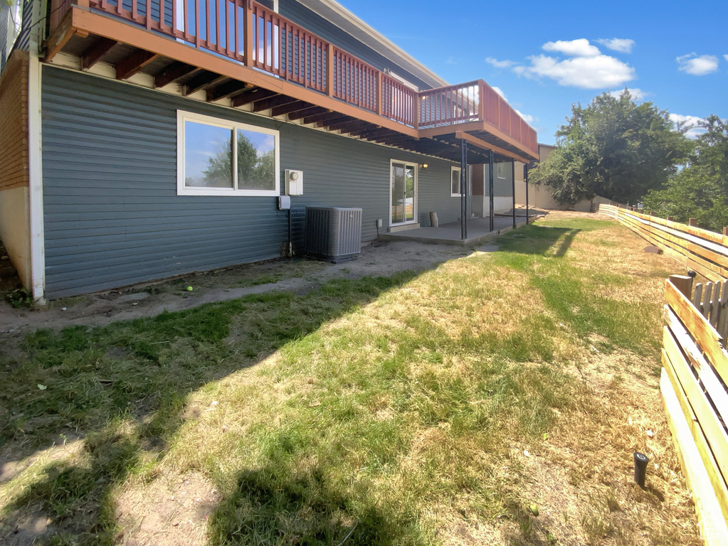 Rear view of house with a deck and a patio