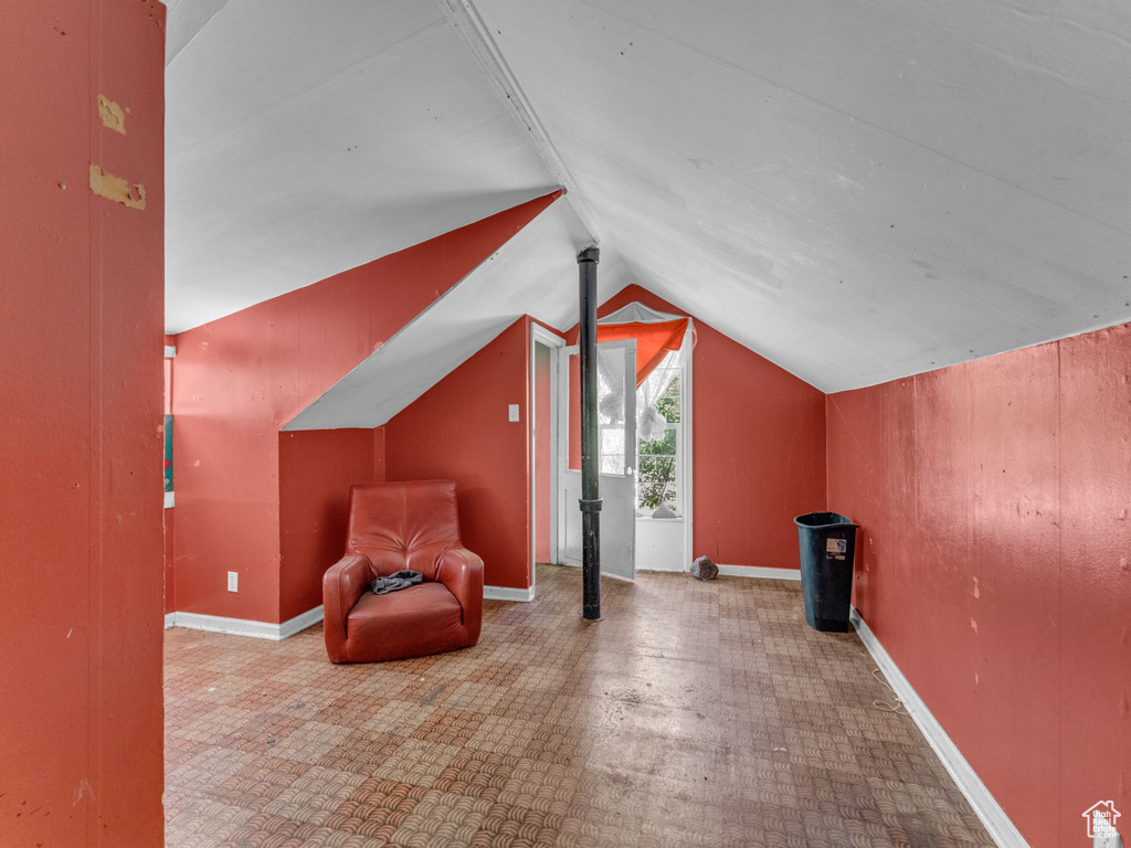 Unfurnished room featuring vaulted ceiling and tile patterned floors