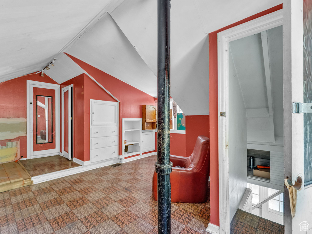Additional living space with vaulted ceiling and tile patterned floors