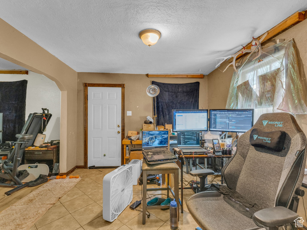Tiled office space featuring arched walkways and a textured ceiling
