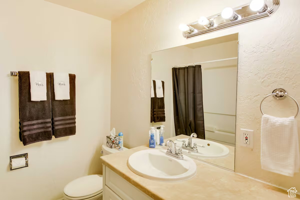 Bathroom featuring a shower with shower curtain and vanity