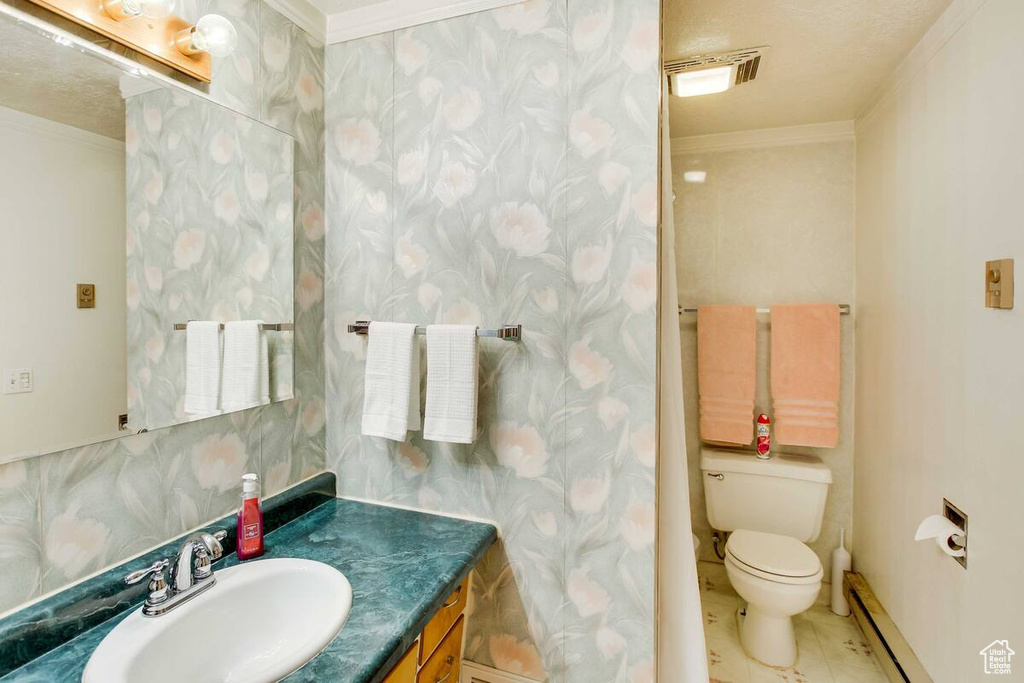 Bathroom featuring crown molding, vanity, a baseboard radiator, and tile patterned flooring