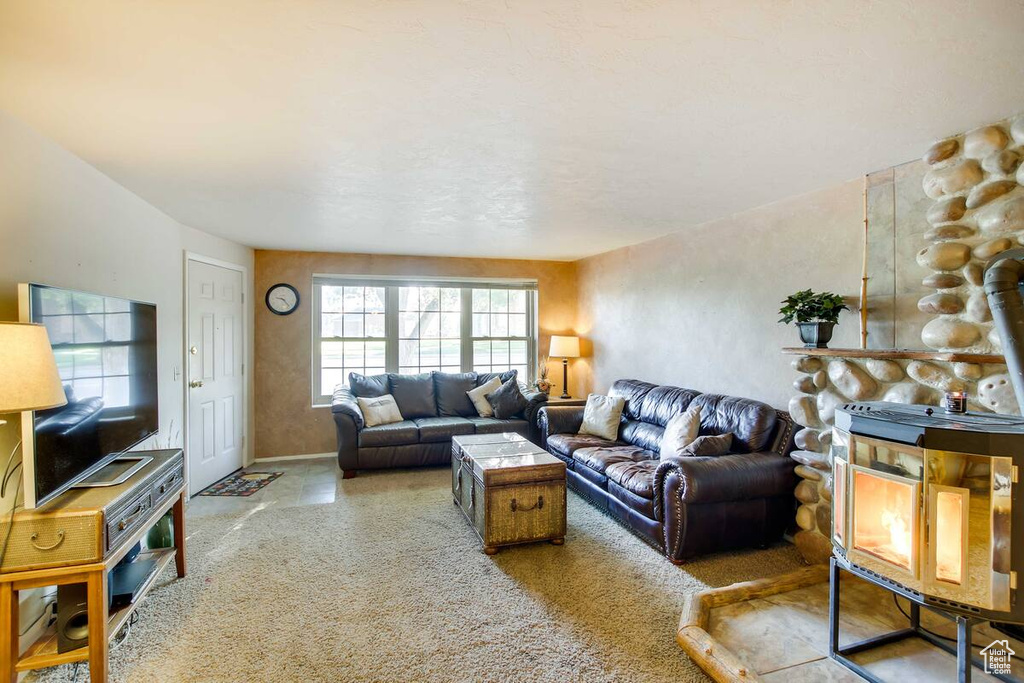 Carpeted living room with a wood stove and baseboards