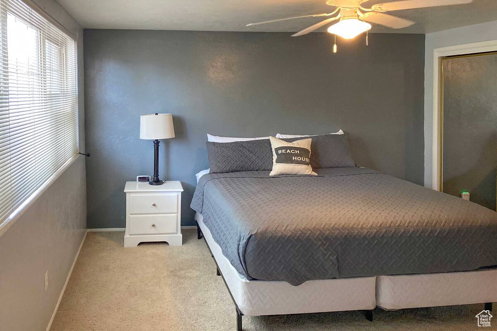 Carpeted bedroom featuring baseboards and ceiling fan