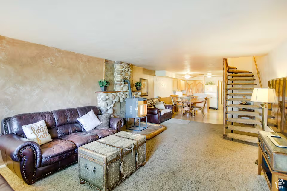 Carpeted living room featuring stairs