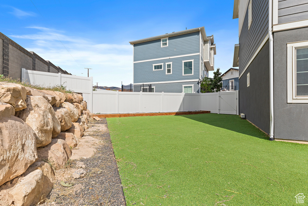 Fenced backyard featuring a gate