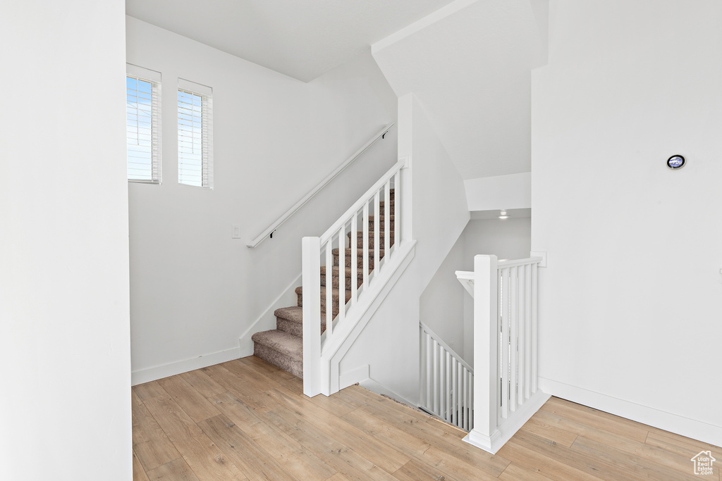 Stairway with hardwood / wood-style flooring and baseboards