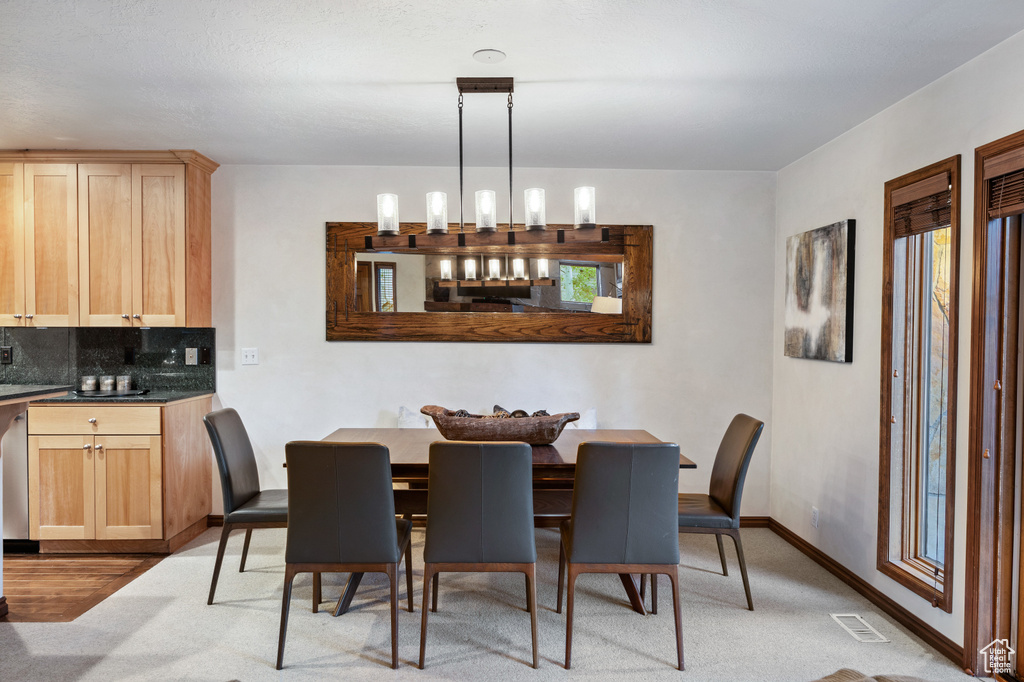 Dining room with baseboards and light carpet