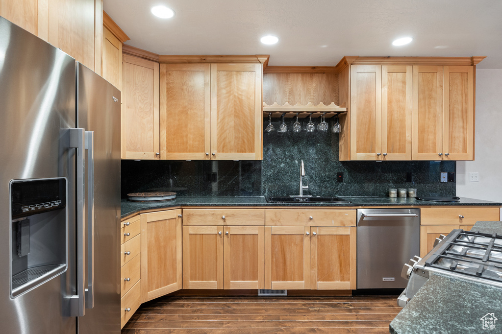 Kitchen with stainless steel appliances, light brown cabinetry, dark wood finished floors, tasteful backsplash, and recessed lighting