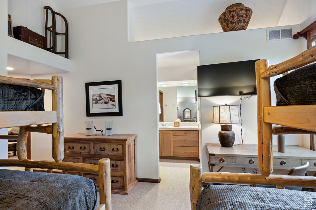 Bedroom featuring connected bathroom and light carpet
