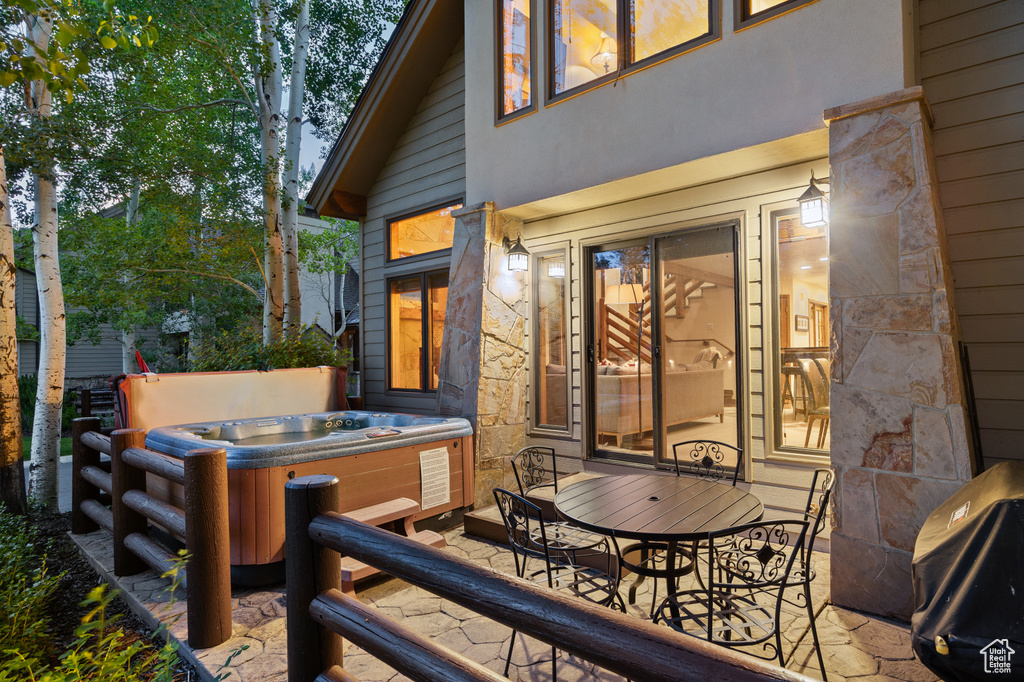 Wooden deck with a hot tub and a patio area