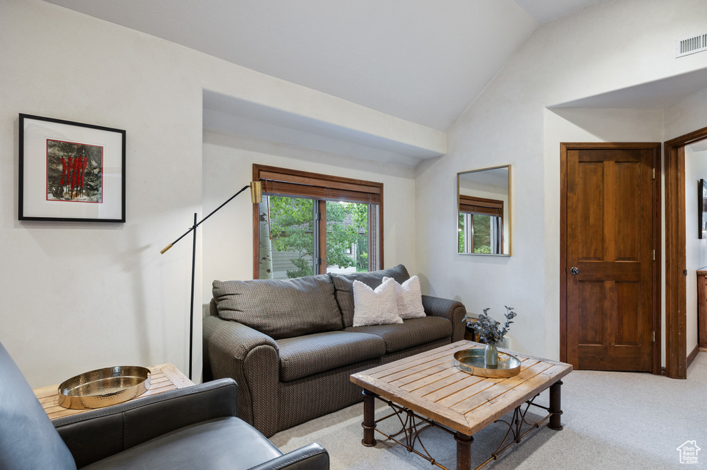 Living room featuring vaulted ceiling and light colored carpet