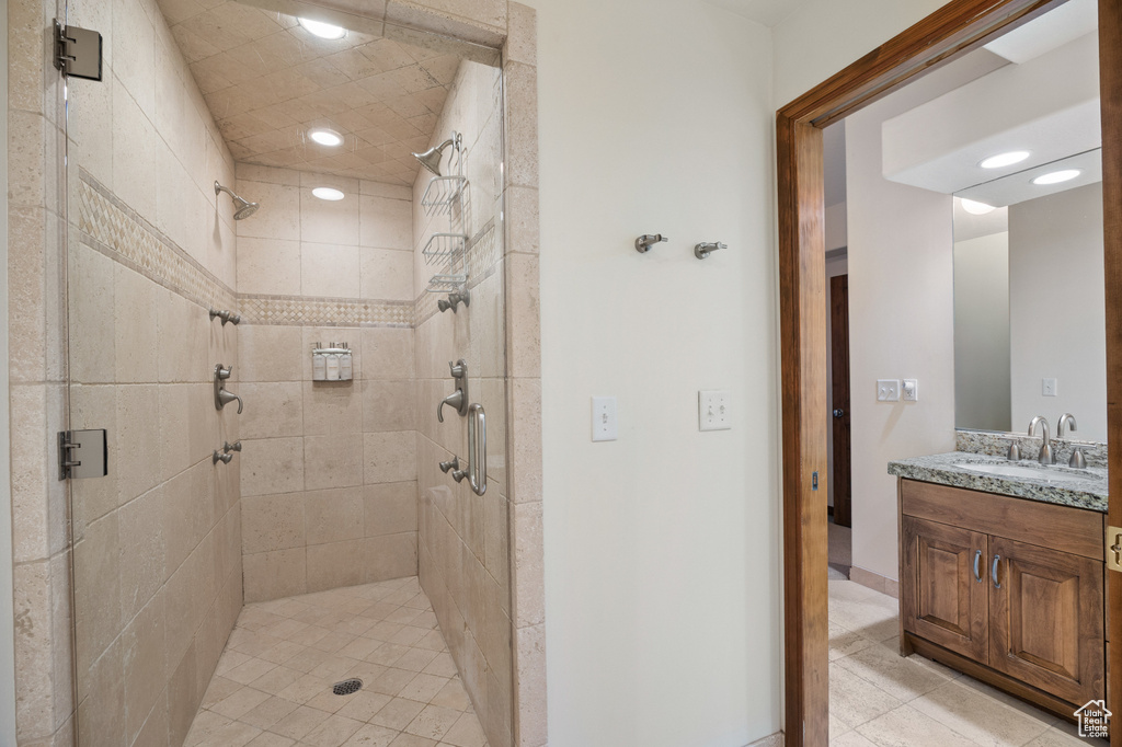 Bathroom featuring a stall shower, vanity, tile patterned floors, and recessed lighting