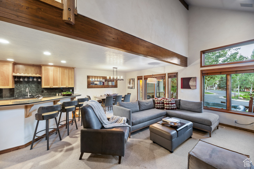 Living room featuring light colored carpet, a towering ceiling, a chandelier, and recessed lighting