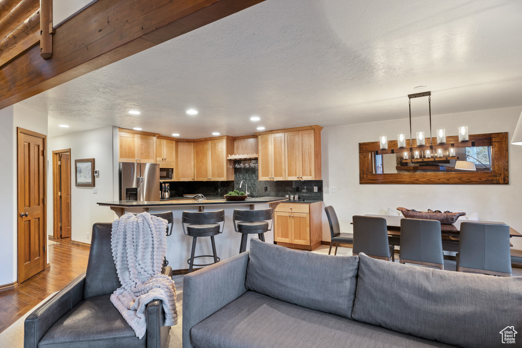 Living area with light wood-style floors, recessed lighting, a chandelier, and a textured ceiling