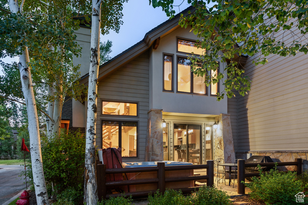 Rear view of property featuring stone siding and stucco siding